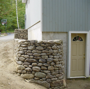 Custom stone retaining wall by DeJohn Landscaping
