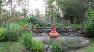 Quaint garden with patio and stone wall in Concord NH by DeJohn Landscaping